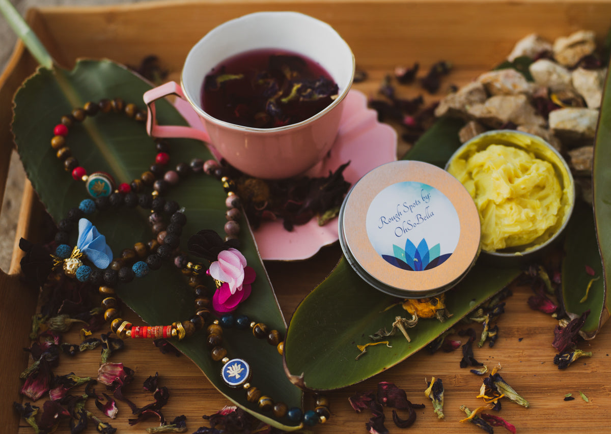 A cup of hibiscus tea, flowers, and colorful jewelry from Oh So Bella